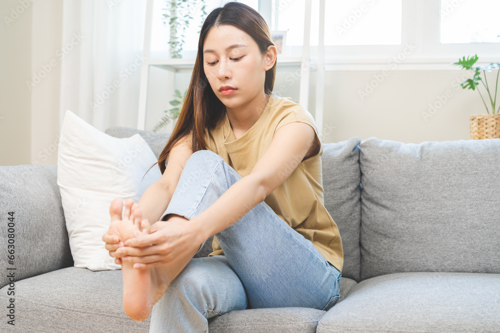 Health care foot pain, suffering asian young woman hand rubbing