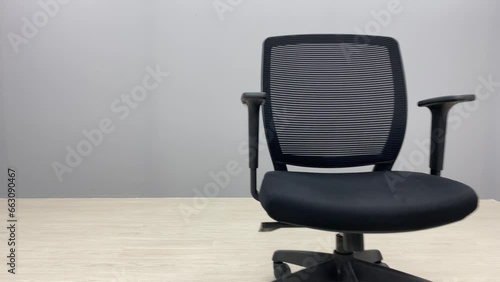 Black office chair sliding on floor indoor room with text empty space.