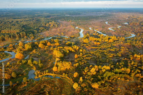 Obraz na płótnie Aerial view of autumn nature on early morning. Aerial view on woods, meadows and winding river flowing between them. Belarus is a coutry of lakes and rivers. w salonie