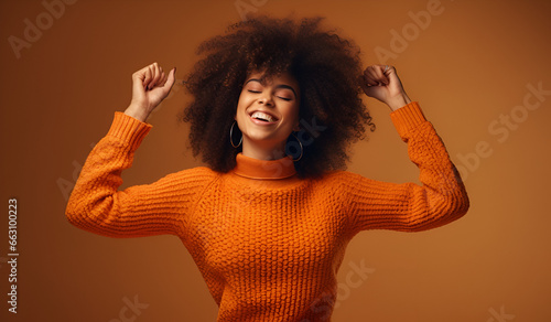 happy woman dancing carefree and raising her fists with a smile. Concept of good feelings and emotions