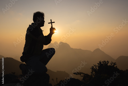 Silhouette of christian prayers raising hand while praying to the Jesus spirituality and religion,man praying to god. Christianity concept. Pray for god blessing to wishing have a better life.