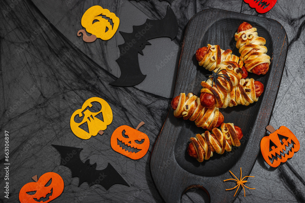 Spooky sausage mummies for Halloween party. Funny seasonal food, homemade baking, traditional decor