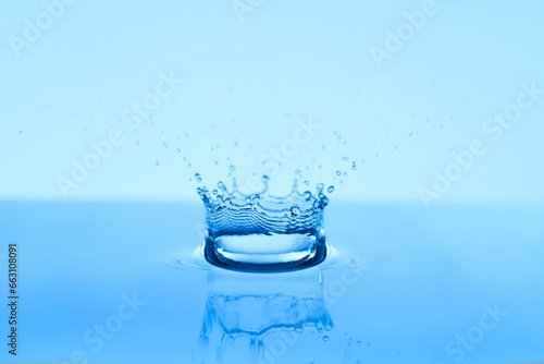 Group of water droplets fall and bounce on a water surface