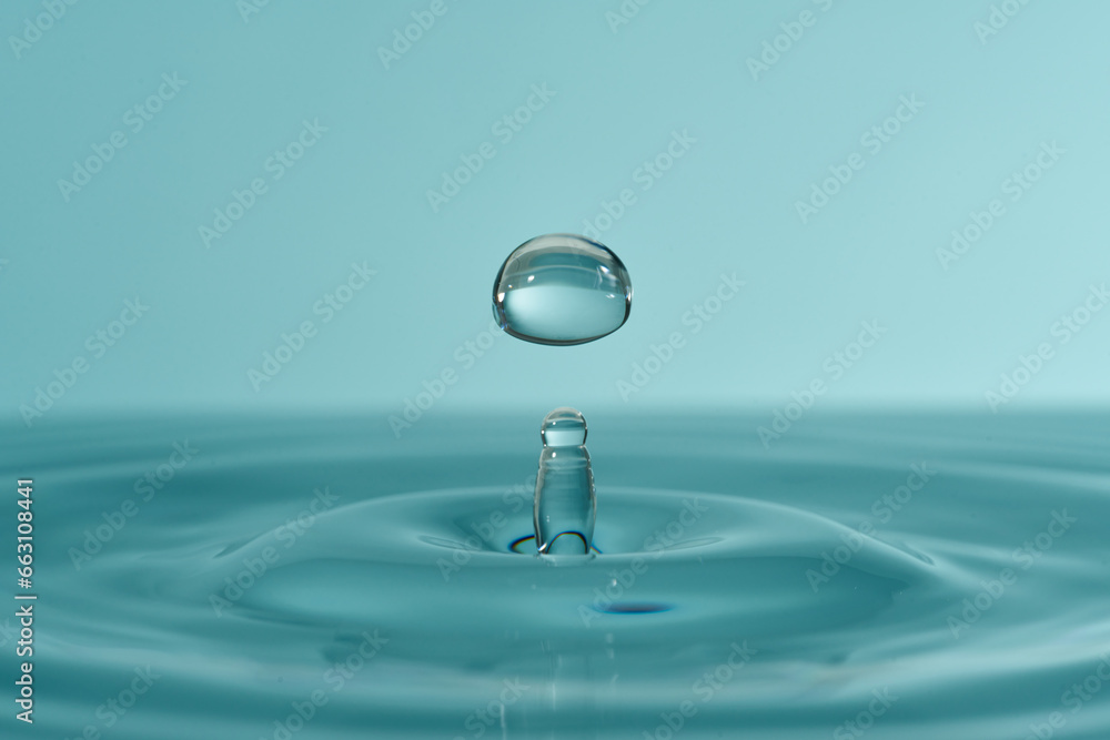 Group of water droplets fall and bounce on a water surface