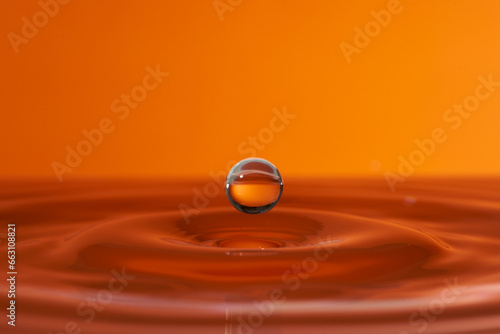 Group of colorful water droplets fall and bounce on a water surface