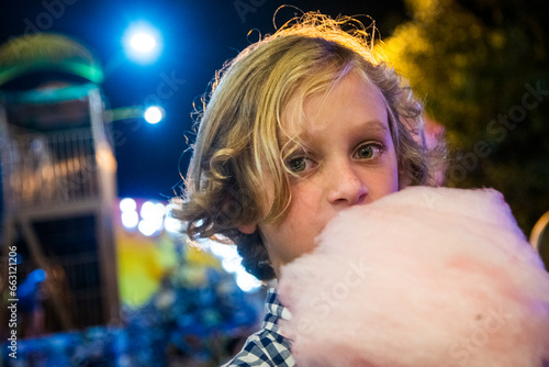 Young boy enjoys cotton candy at the fair photo