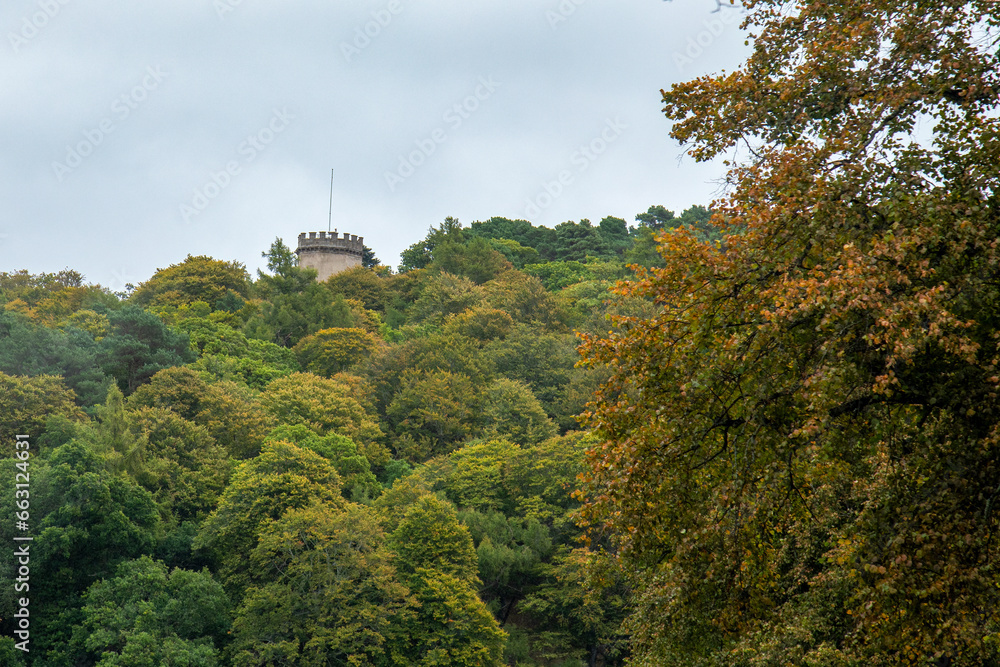 castle in the forest surrounded by autumnal coloured trees in fall