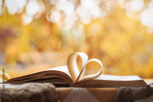 Read Books Concept. Heart Shaped Book Pages in Autumn Window Background. Love to Reading Book in Autumn Time Holiday. 