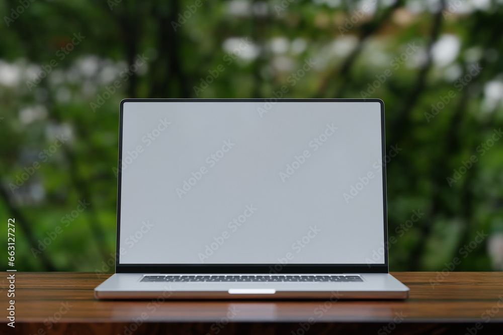 Laptop with blank white screen on wooden table outdoors Laptop with blank white screen on wooden table outdoors