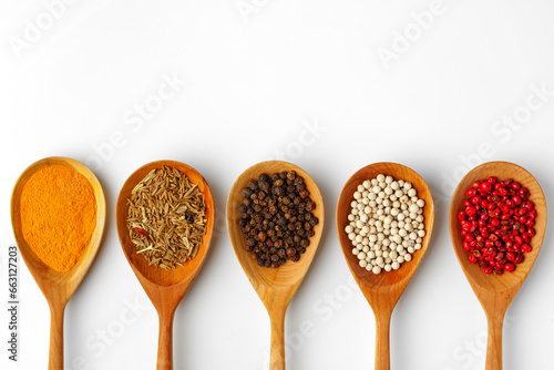 Wooden spoons with various spices isolated on white background