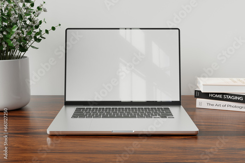 Laptop with blank white screen on wood table with modern workplace background