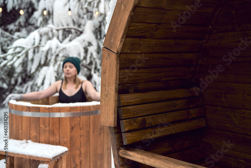 Caucasian woman during the winter bath in tube outdoors