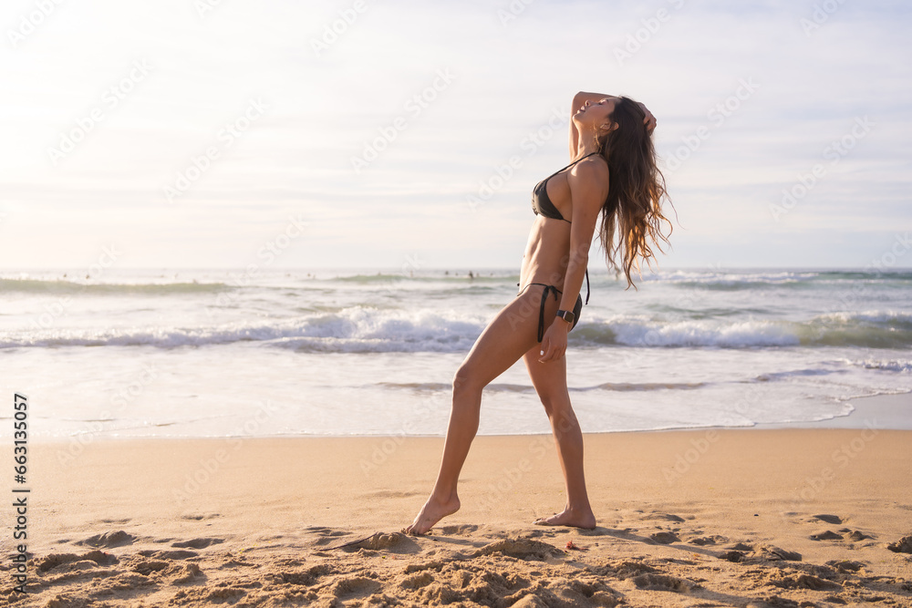 Fototapeta premium Model wearing bikini walking along the beach