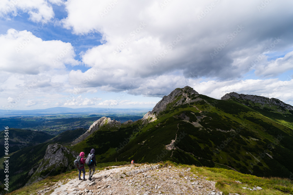 Travelers tourists go to Mount Giewont in the Polish Tatras.