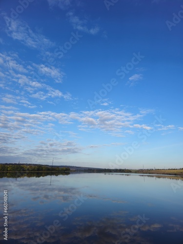 A body of water with clouds in the sky