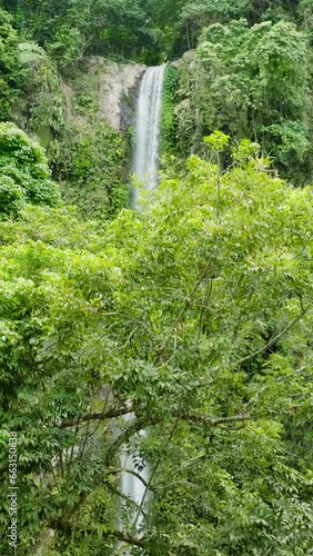 Katibawasan Falls with cold and freshwater surrounded by lush greenery. Camiguin Island. Philippines. View from above. Vertical video. photo