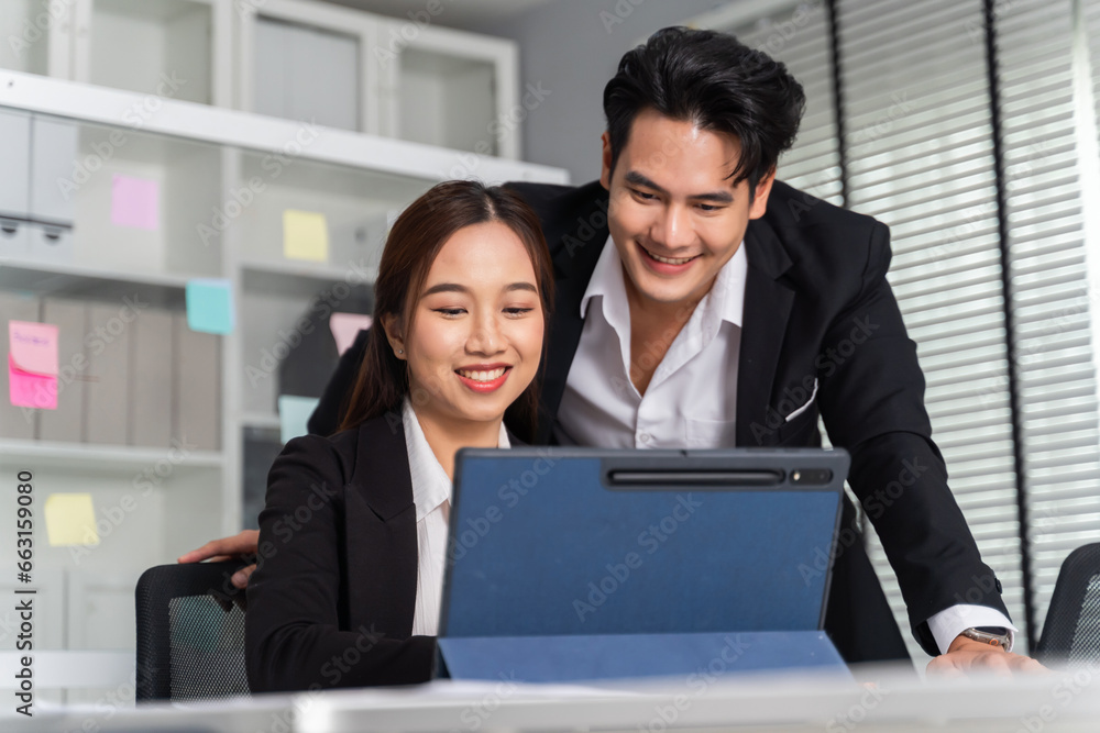 Asian businessman and businesswoman working togetheri n the office meeting room and brainstorming in a company formal business attire. Business happiness in the workplace. Asian businessman and businesswoman working togetheri n the office meeting room and brainstorming in a company formal business attire. Business happiness in the workplace.