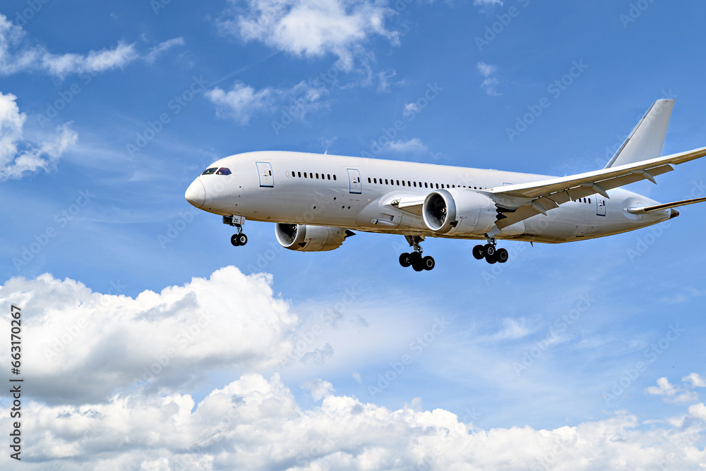 Obraz premium Boeing 787-8 Dreamliner passenger plane landing at the airport, under a blue sky with white clouds