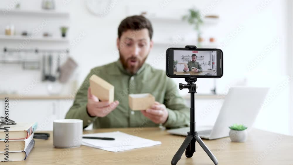 Blurred background of impressed male showing off wonderful wristwatch with dark grey band during video blogging. Talkative delighted blogger answering followers questions about digital devices. Blurred background of impressed male showing off wonderful wristwatch with dark grey band during video blogging. Talkative delighted blogger answering followers questions about digital devices.