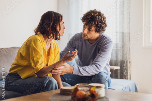 Photos Man and woman are sitting at sofa and arguing