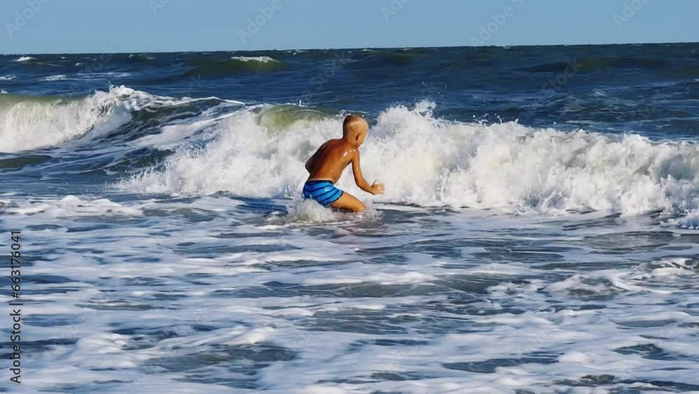A child swims in the Sea of Azov. A boy jumps into the sea waves from the beach. The boy dives into the foaming wave. The delight of a child from a vacation at the sea. Happy moments with children. 4K A child swims in the Sea of Azov. A boy jumps into the sea waves from the beach. The boy dives into the foaming wave. The delight of a child from a vacation at the sea. Happy moments with children. 4K