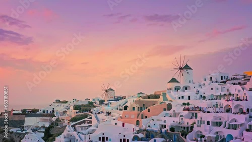 Sunset sky over Santorini island in Greece. Windmills of Oia town against sky