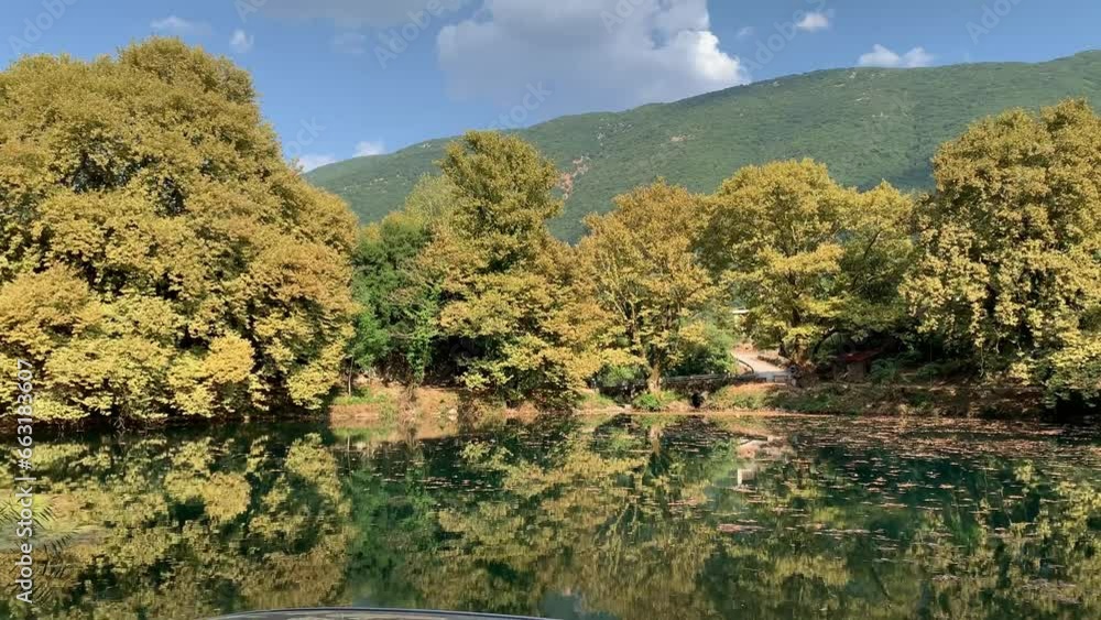 Panning view of a beautiful lake with plane trees around in Greece during a summer day Panning view of a beautiful lake with plane trees around in Greece during a summer day