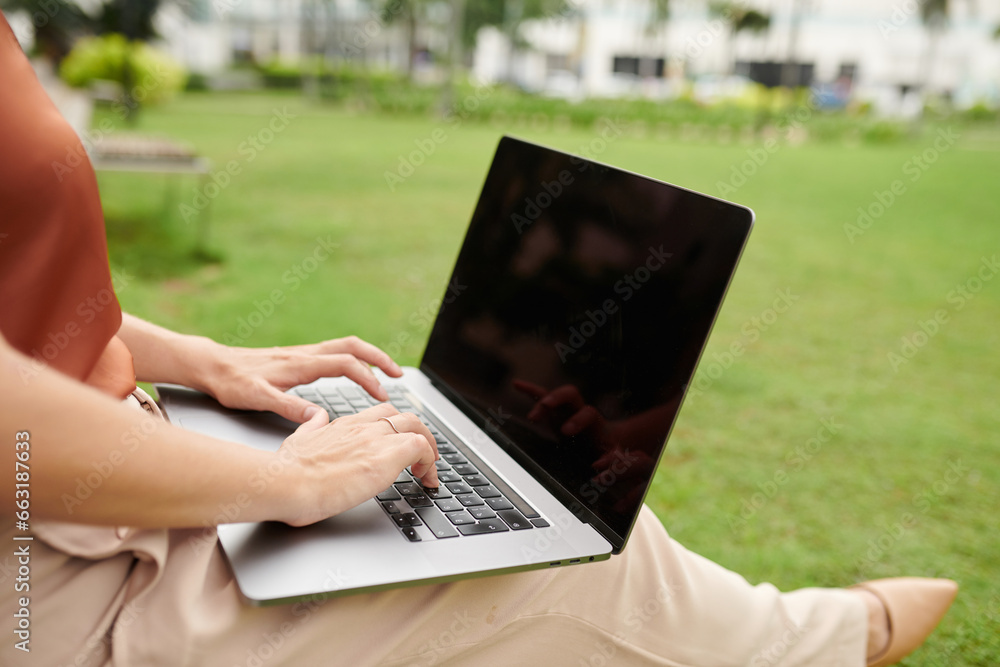 Closeup image of businesswoman working on laptop in city park Closeup image of businesswoman working on laptop in city park