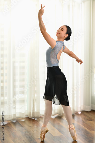 Beautiful young ballerina in pointe shoes dancing in ballet school