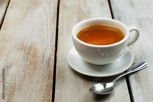 A cup of fragrant hot tea on a light background. Herb tea. Hot drink. White cup with tea.