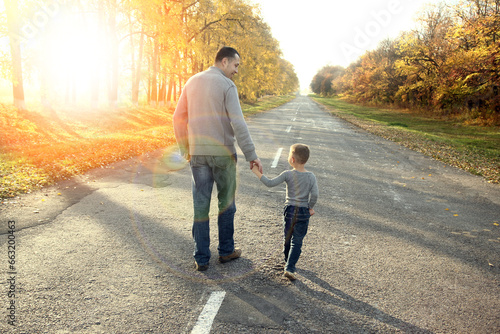 A Happy parent with child are walking along the road in the park on nature travel