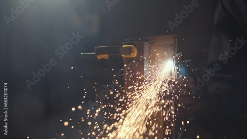 A man works with a circular saw. Sparks fly from hot metal. The man worked hard on the steel. Time-lapse close-up of a garage. photo
