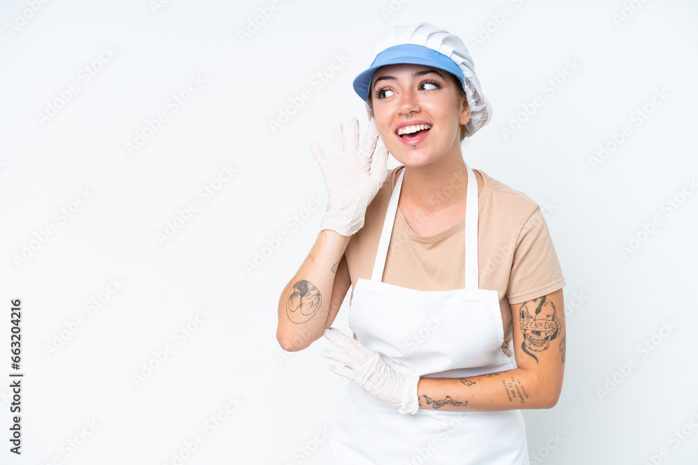 Fishmonger wearing an apron and holding a raw fish isolated on white background listening to something by putting hand on the ear Fishmonger wearing an apron and holding a raw fish isolated on white background listening to something by putting hand on the ear