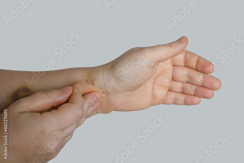 Woman hand with a band aid on white background