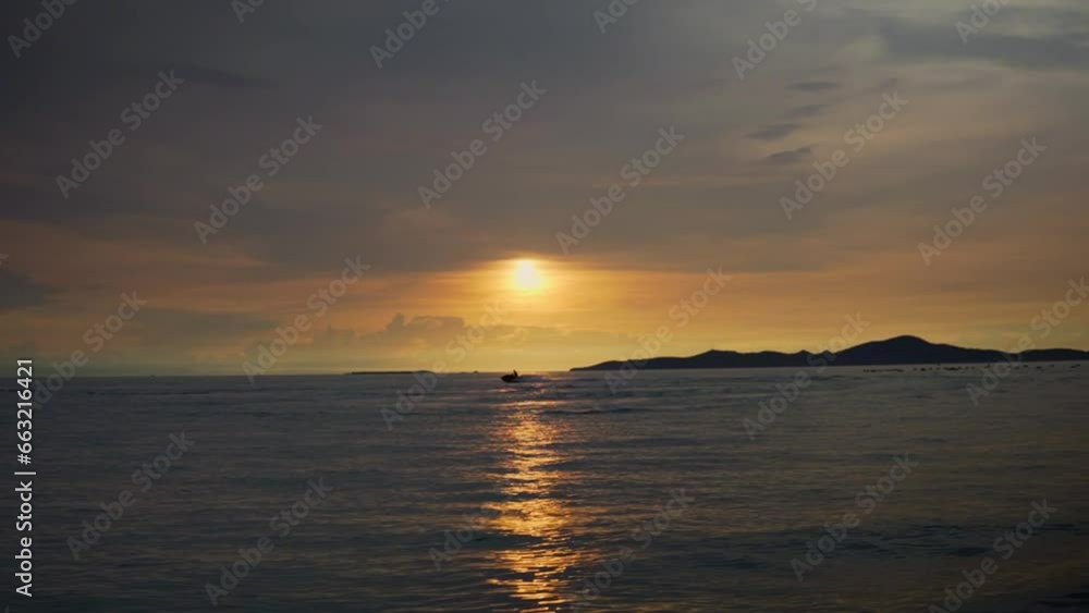 Pattaya Beach Sunset In Thailand; Lone Jet Ski Skidding Across The Beautiful Sunlit Ocean Horizon. Pattaya Beach Sunset In Thailand; Lone Jet Ski Skidding Across The Beautiful Sunlit Ocean Horizon.