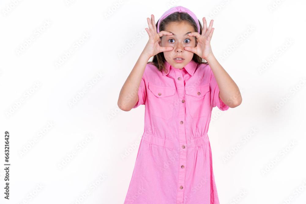 Beautiful little kid girl wearing pink dress keeping eyes opened to find a success opportunity. Beautiful little kid girl wearing pink dress keeping eyes opened to find a success opportunity.