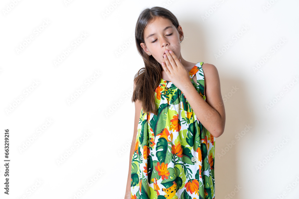 Beautiful kid girl wearing floral dress yawns with opened mouth stands. Daily morning routine Beautiful kid girl wearing floral dress yawns with opened mouth stands. Daily morning routine