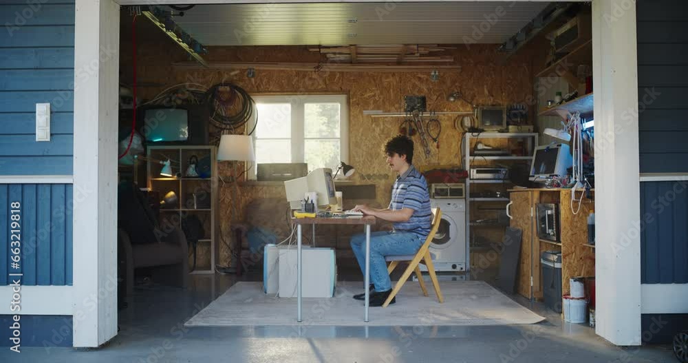 Caucasian Male Software Developer Programming On Old Desktop Computer In Retro Garage With Random Appliances. Man Working On Innovative Fintech Startup Company In Nineties. Nostalgia Concept. Caucasian Male Software Developer Programming On Old Desktop Computer In Retro Garage With Random Appliances. Man Working On Innovative Fintech Startup Company In Nineties. Nostalgia Concept.