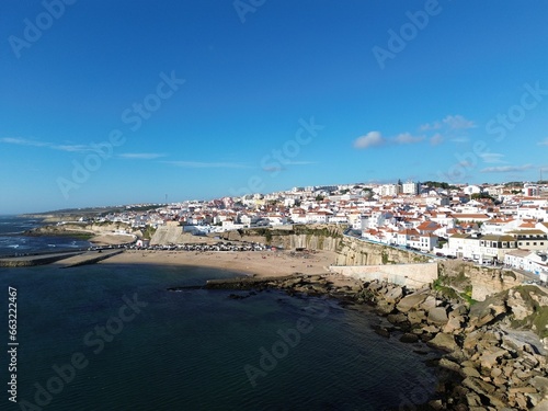 a beach and sea next to a small town with houses