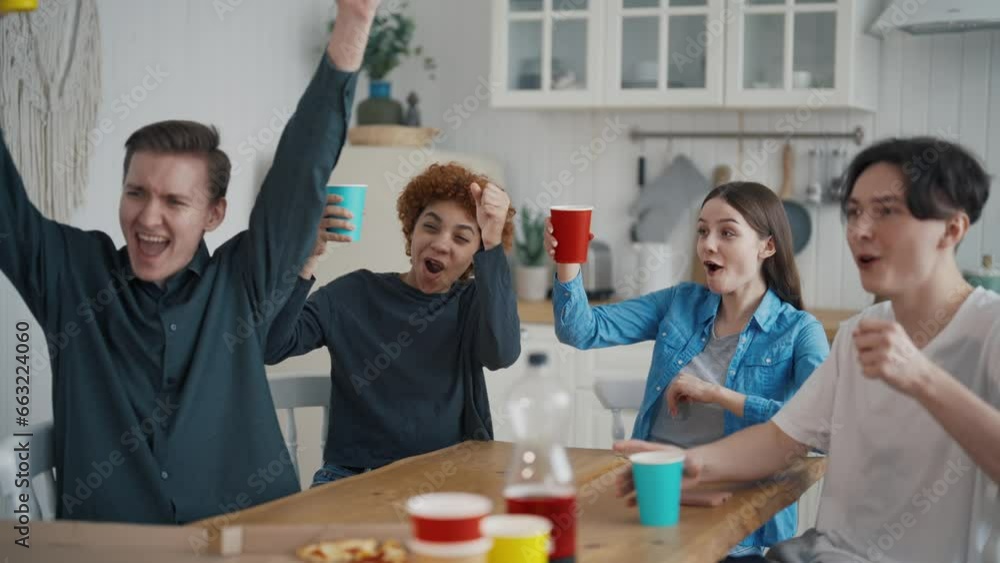 Company happy young friends clink drinks in paper cups eating pizza sitting on kitchen at home. Colleagues students best friends enjoying time together laughing talking. Party pastime leisure concept. Company happy young friends clink drinks in paper cups eating pizza sitting on kitchen at home. Colleagues students best friends enjoying time together laughing talking. Party pastime leisure concept.