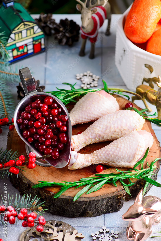 Raw chicken drumsticks prepared for Christmas dishes in a Christmas decor.
