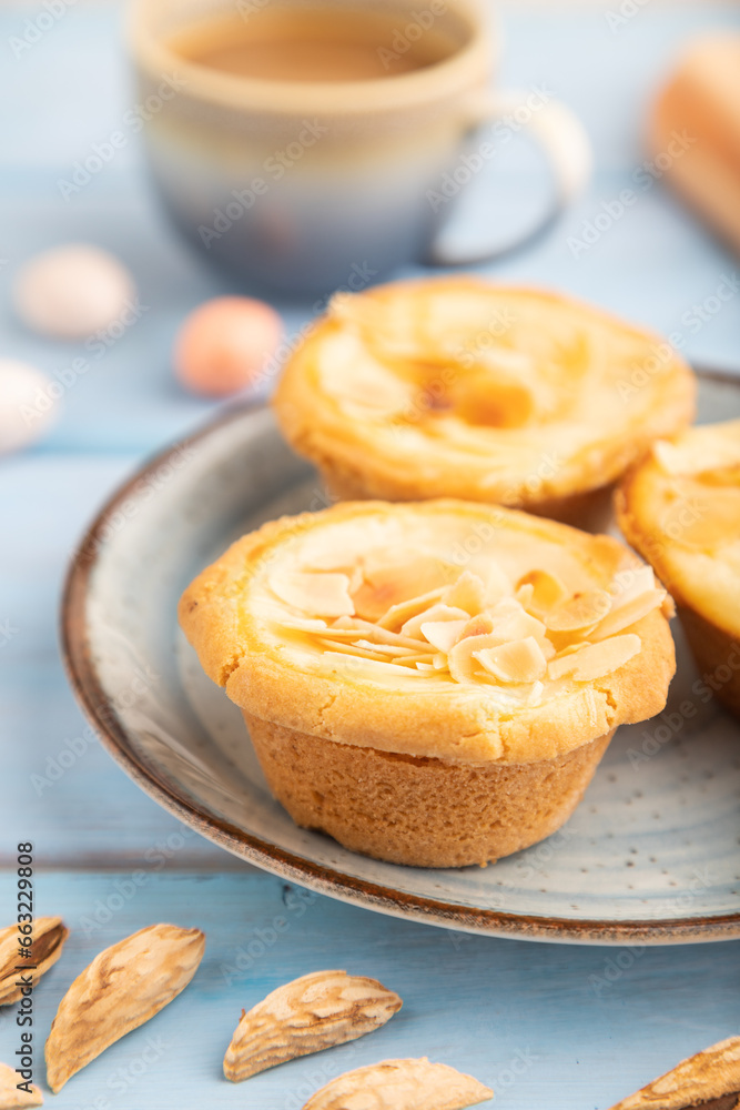 Traditional portuguese cakes pasteis de nata, custard small pies on blue wooden. Side view, selective focus. Traditional portuguese cakes pasteis de nata, custard small pies on blue wooden. Side view, selective focus.