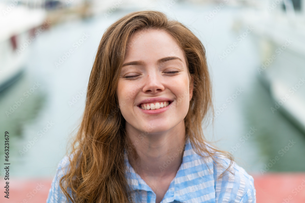 Young redhead woman at outdoors . Portrait