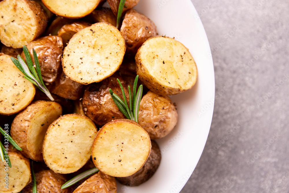 Delicious baked potatoes with rosemary on a gray background Delicious baked potatoes with rosemary on a gray background
