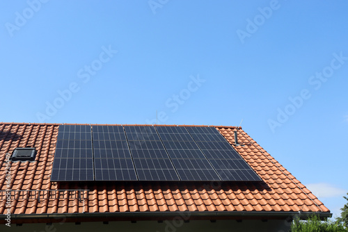 Solaranlage auf einem Einfamilienhaus mit blauem Himmel in Deutschland	