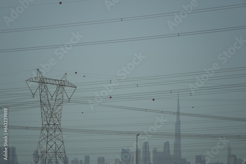 high power line constructions with Dubai Burj Khalifa in background