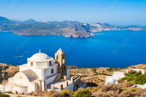View of church in Plaka village with white houses and sea view from high vantage point, Milos island, Cyclades, Greece