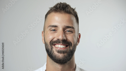 Handsome person look at camera close up. Young adult man face portrait. Stylish 30s guy on isolated white background. Attractive male model. Modern millennial people. Brutal bearded style. Barber shop photo