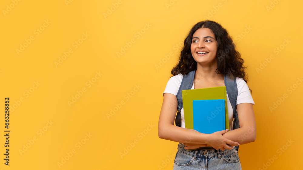 Young smiling happy indian woman student on yellow - obrazy, fototapety, plakaty 
