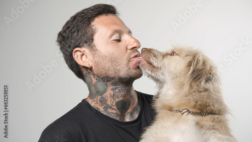 Cute dog lick owner face. Young adult man kiss pet close up. Happy person portrait with best friend. Brutal animal lover. Joy guy care puppy. Active doggie have fun. Nice family life. Doggy play game.